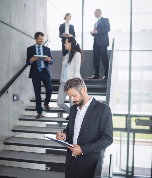 Businessman writing on clipboard in office